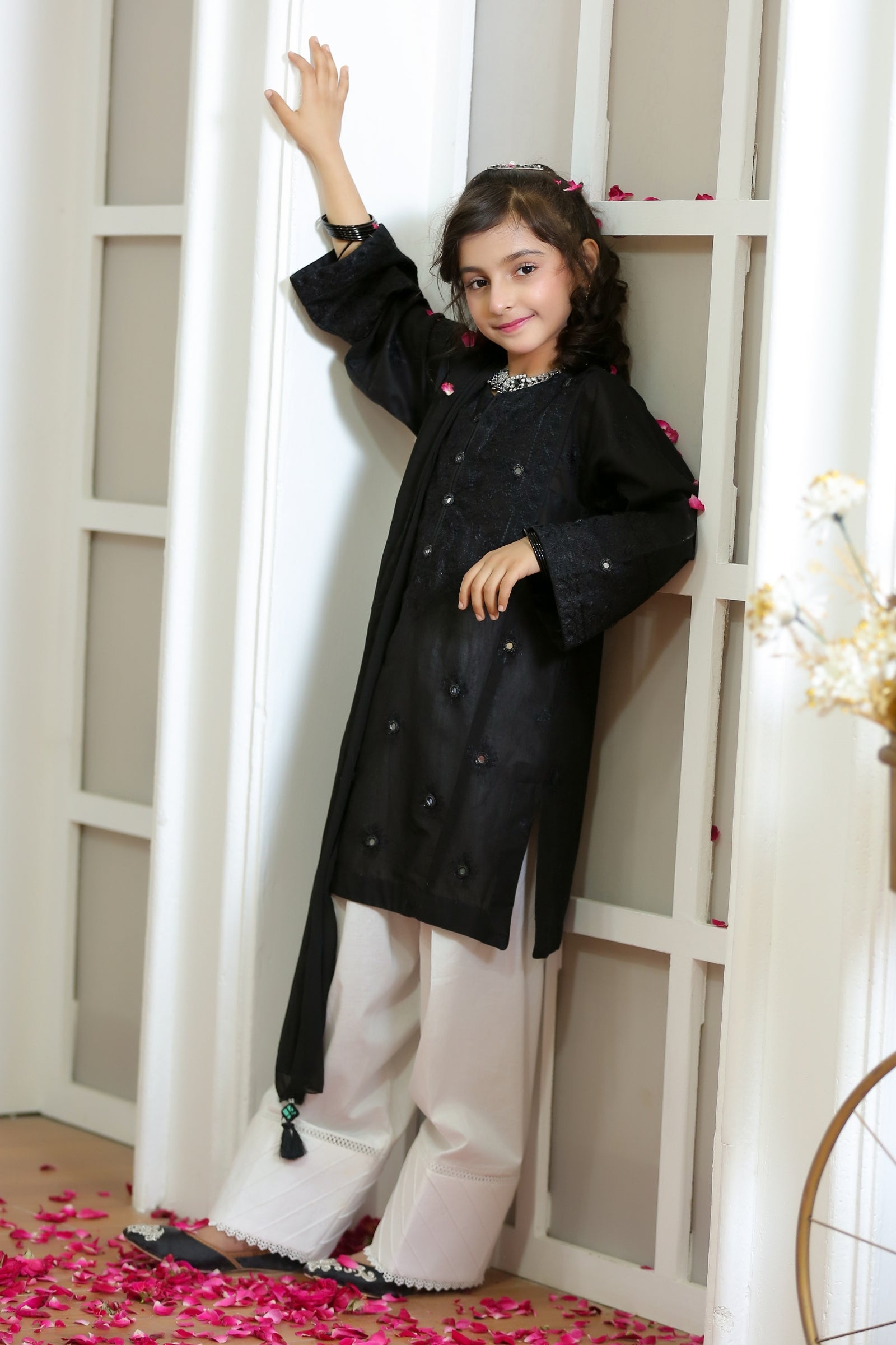 Young girl wearing a black and white Eastern wear suit with embroidery from Zilenoor Collection.